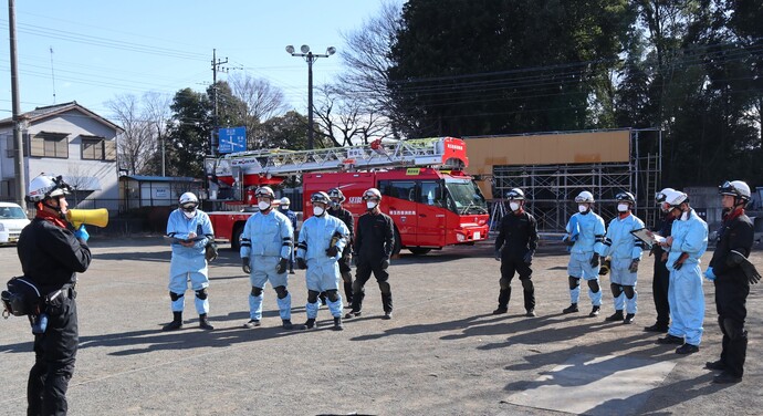 指導員1名が5人1組と6人1組の2組に対して想定内用を伝えている写真