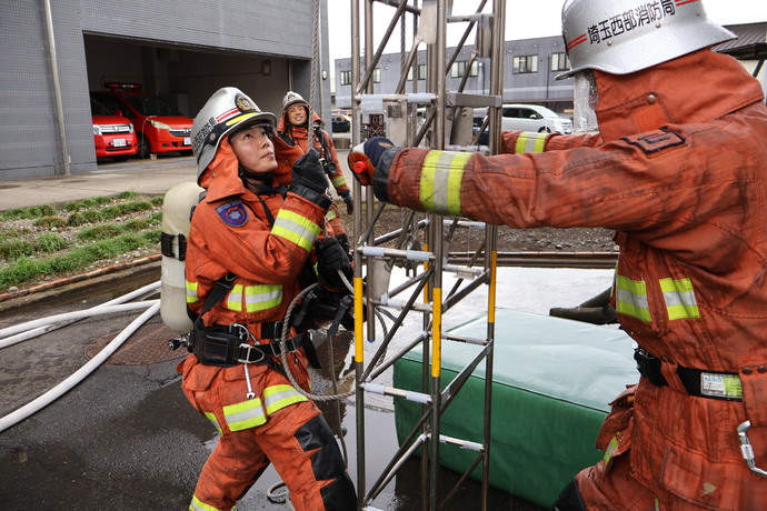 隊員が三連はしごを操作している写真