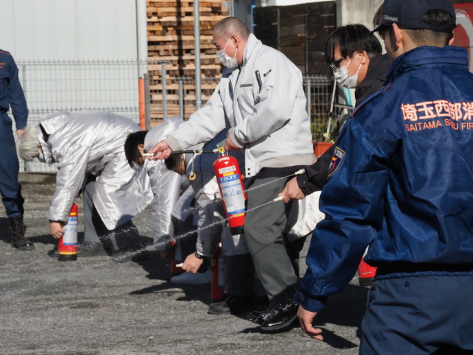 丸大観光職員による水消火器を使用した初期消火訓練の写真
